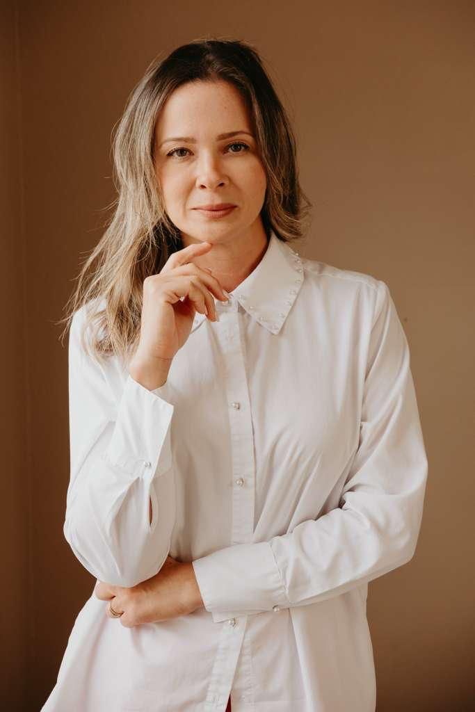Larissa Lopes de camisa branca, em um retrato com luz acolhedora